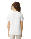 A woman with curly hair pulled back in a ponytail is shown from behind wearing a plain white short-sleeve t-shirt and light-colored pants against a white background.