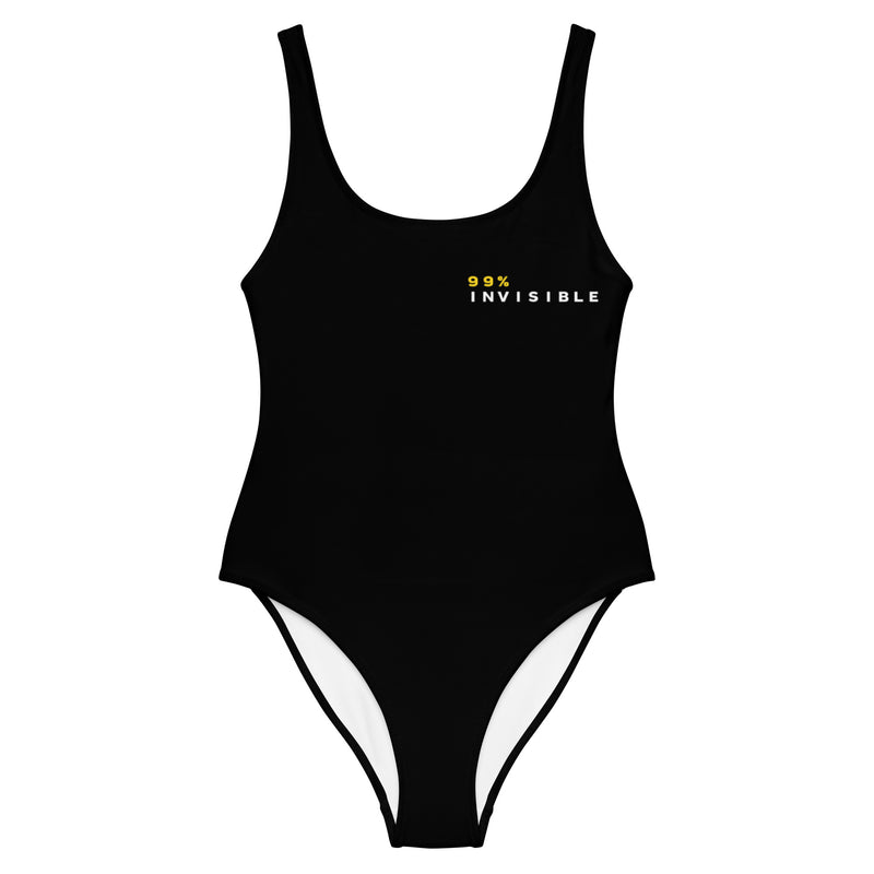 A black one-piece swimsuit displayed against a white background with the text '99% INVISIBLE' in yellow and white printed on the left chest.