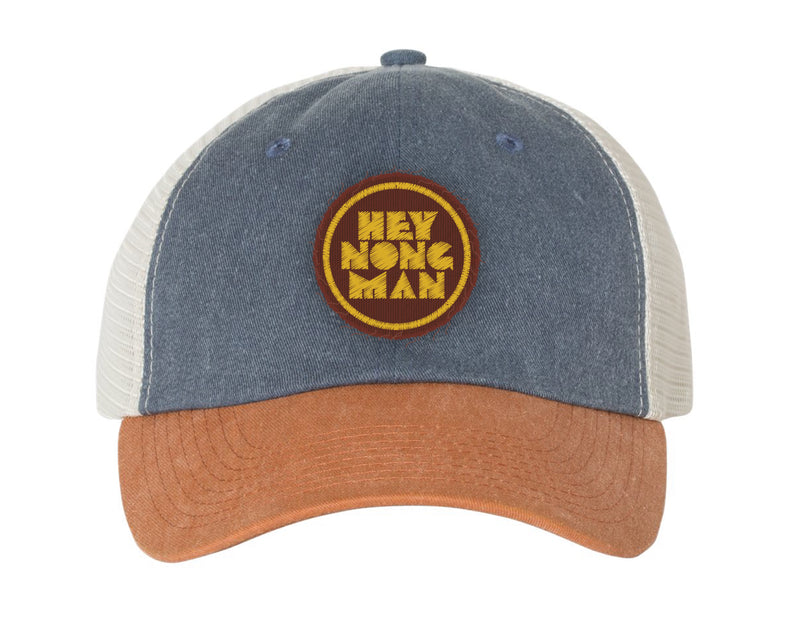 Trucker hat with blue top, tan brim, and circular patch featuring the text HEY NONG MAN in yellow on brown background.