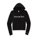 Front product view of a black cropped hoodie with large white gothic blackletter text reading ‘Immortally Weird’ across the chest. The hoodie has a drawstring hood, cropped silhouette, long sleeves, ribbed cuffs and hem, and a small print near the wearer’s left cuff reading ‘MORBID Live’.
