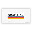 A large white towel with the word 'SMARTLESS' in bold black letters above a horizontal rainbow stripe. The 'SiriusXM' and 'SMARTLESS' logos appear in the bottom right corner.