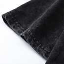 Close-up detail of the hoodie’s sleeve hem showing the black washed fabric texture and stitched edge, highlighting the soft material and slightly worn finish.