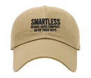 Front view of a tan baseball cap with the word 'SMARTLESS' in large black embroidered letters, followed by the slogan 'GENIUS LOVES COMPANY. SO DO THESE GUYS.' in smaller black text centered below.