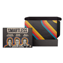 Black gift box printed with ‘SMARTLESS’ in beige above photos of hosts ‘Jason Bateman,’ ‘Sean Hayes,’ and ‘Will Arnett.’ The open box interior shows diagonal red, blue, and yellow stripes.
