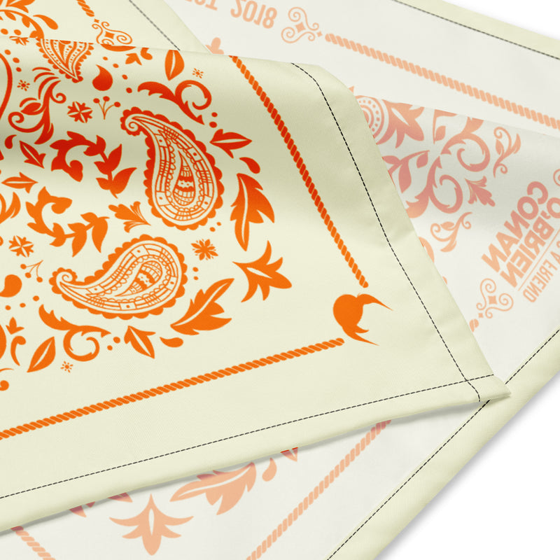 Vibrant orange paisley and floral design on a soft yellow background with a decorative border.
