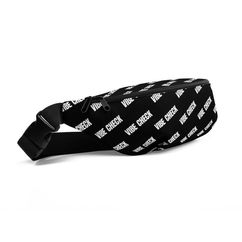 A side view of a black fanny pack featuring a white repeating 'VIBE CHECK' pattern, adjustable strap, and a zippered main compartment with dual zipper pulls.