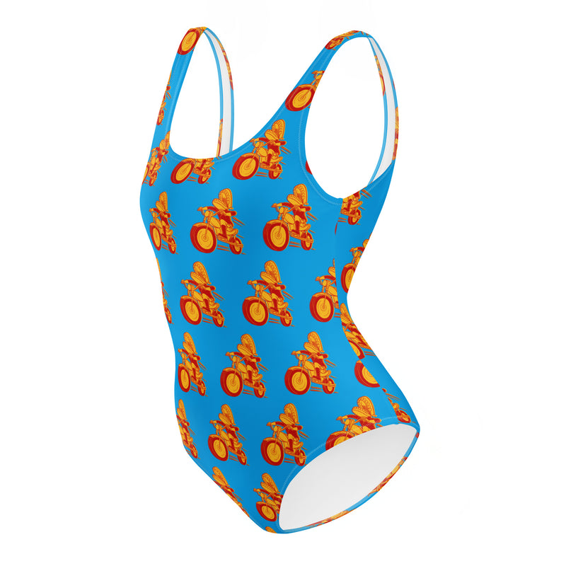 Colorful one-piece swimsuit featuring Comedy Bang! Bang! logo with vibrant orange and yellow bicycle patterns on a blue background.