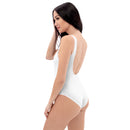 A woman poses with her back turned in a white one-piece swimsuit with a scoop back and no visible design elements on the back.