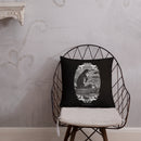 Square black throw pillow displayed on a metal wire chair with a beige seat cushion against a textured gray wall. The pillow features a black-and-white vintage illustration of a hooded skeleton rowing a boat, framed by ornate scrollwork, with ribbon text reading ‘MORBID’ and ‘2018,’ and the phrase ‘SHE BECOMETH SO LAME’ beneath the artwork.