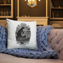 Square white throw pillow displayed on a beige sofa with a chunky knit gray blanket. The pillow features a black-and-white vintage illustration of a hooded skeleton rowing a small boat beneath ornate scrollwork banners. The lower ribbon reads ‘MORBID’ and ‘2018,’ and the caption below the oval illustration reads ‘SHE BECOMETH SO LAME.’