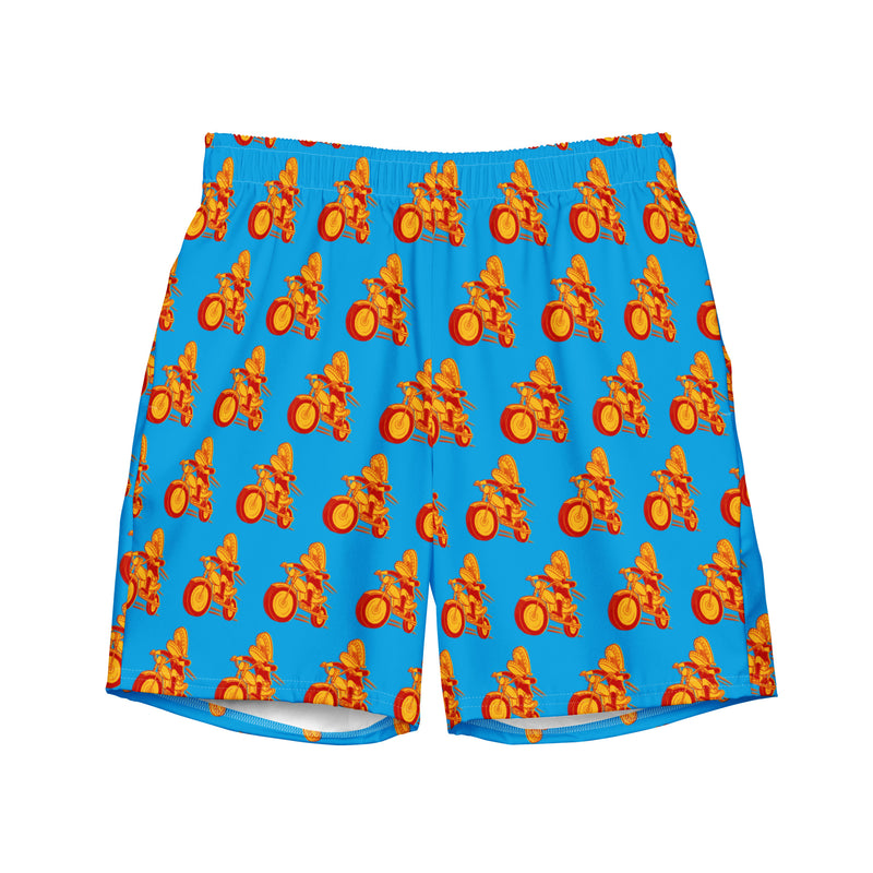 Colorful swim shorts with a blue background featuring a 'Comedy Bang! Bang!' logo with repeating pattern of cartoonish figures on motorcycles.