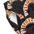 A close-up of the swim trunks’ outer fabric showing the rainbow 'BYEEEEEEE' pattern, with a partial view of the white mesh interior of the side pocket.