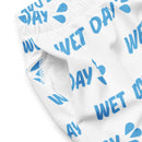 A close-up of the side pocket of white swim trunks with 'WET DAY' droplets pattern, showing the interior white mesh lining and gathered elastic waistband.