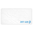 Flat lay of a large white rectangular towel with subtle fabric ripples. In the lower right corner, light blue ‘WET DAY’ text and splash icon are printed. The rest of the towel remains blank, emphasizing minimal design placement.