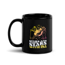 Black coffee mug with hands holding a planet and colorful text reading 'Stars and Stars with Isa'