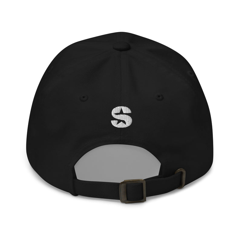 A black classic dad hat viewed from the back, featuring a white embroidered 'S' logo above the adjustable brass buckle strap.