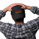 Person wearing a black dad hat with the 'SEXY INDIFFERENCE' graphic on the front, resting their hands on top of their head. The hat is paired with a black and gray plaid shirt.