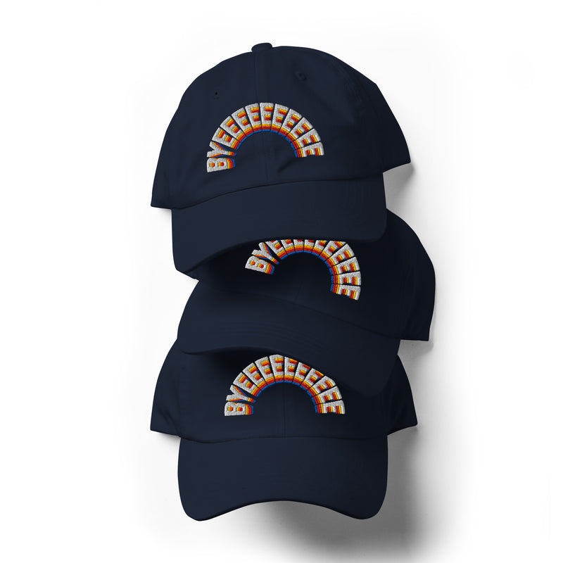 A stack of three navy blue dad hats, each embroidered with the word 'BYEEEEEEEE' in a colorful rainbow arc across the front.