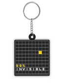 Front of black square keychain featuring a grid design with a single solid yellow square and the text '99% INVISIBLE' below it.
