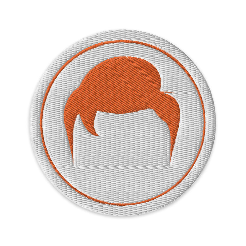 Stylized orange hair emblem on a round patch with a textured white background