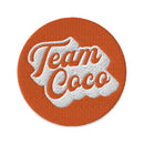 Circular patch with the text 'Team Coco' in white and orange on a textured background.