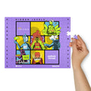 Close-up of a hand holding a puzzle piece near the right edge of a mostly completed rectangular jigsaw puzzle. The design features the same six-panel comic-style artwork with bright characters and text reading 'HIDDEN LEVELS,' '99% Invisible,' and 'Endless Thread,' bordered in purple with 'WBUR' and 'SiriusXM' logos along the bottom.