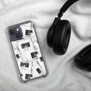 Clear iPhone case displayed on a soft white fabric surface beside black over-ear headphones. The case features an all-over black-and-white collage design of overlapping newspaper-style clippings and podcast-themed graphics, including visible text reading ‘Keep it weird,’ ‘Morbid Podcast,’ ‘MORBID,’ and ‘05012018.’