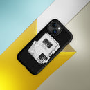 Matte black MagSafe tough iPhone case displayed at an angle against geometric yellow, white, and light blue background panels. The case features a centered black-and-white stacked collage design with visible text reading ‘Keep it weird,’ ‘Morbid Podcast,’ ‘MORBID,’ and ‘05012018.’