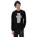 A man facing forward wearing a black long sleeve shirt with the phrase 'THE VIBES ARE OFF' printed in large white vertical letters.