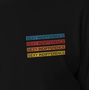 Close-up of the T-shirt design showing the phrase 'SEXY INDIFFERENCE' embroidered four times in stacked lines. Each line is bordered and filled in blue, red, orange, and yellow thread, standing out against the black fabric.