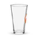 Clear glass pint glass with an orange circle logo featuring a stylized white design of a head with hair