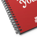 A close-up angled view of the red spiral notebook showing the black wire binding, a portion of the text 'Poetry Loves You', and the smaller 'VIBE CHECK' text at the bottom right.