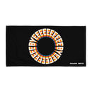 A black towel featuring a circular design made up of repeating text that reads 'BYEEEEEEEE' in bold, retro-style cream letters with orange, pink, blue, and yellow shadows. The text forms a full ring in the center of the towel. In the lower right corner, white logos read 'SiriusXM' and 'SMARTLESS'.