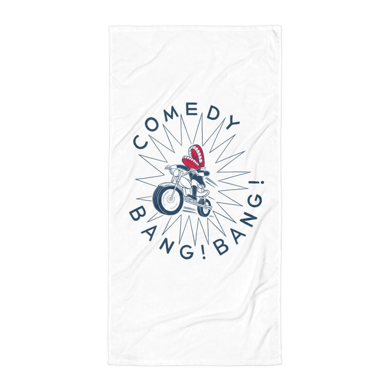 A white towel positioned vertically, featuring the 'Comedy Bang! Bang!' logo with a cartoon chattering teeth character riding a motorcycle, centered against a white surface. 