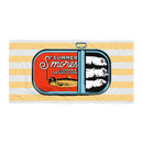Flat lay of a beach towel featuring a sardine can illustration with the words 'Summer S’mores with Conan & the Chill Chums' on a yellow and white striped background.