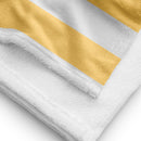 Close-up of the towel’s texture and stitching, showing part of the yellow and white striped design with white terry cloth backing.