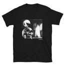 Front view of a black short-sleeve T-shirt featuring a centered monochrome collage graphic on the chest. The design includes three rectangular panels: a raven silhouetted against a full moon, a large detailed skull, and a ghostly white figure standing in a doorway. The text ‘HAUNTED BY MORBID’ appears above the right panel, and ‘MORBID’ is printed below it. The rest of the shirt is solid black.