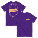 Two purple short-sleeve T-shirts laid flat, one showing the front and one showing the back. The front displays a small yellow and white 'Casuals WITH KATIE NOLAN' logo on the left chest, and the back features a large yellow 'Casuals' design with the text 'EST. 2025' and 'WITH KATIE NOLAN' arranged in a circular layout within a double-line oval.