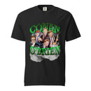 Close-up of black T-shirt graphic showing the words ‘CONAN O’BRIEN’ in glossy bright green 3D lettering. Centered between the text is a collage of Conan O’Brien in various outfits and expressions, including a suit, guitar performance, and a colorful helmet. The background features stylized lightning and billowing gray clouds for a bold, theatrical effect.