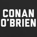 Close-up of the centered chest graphic on a black T-shirt showing large white varsity-style block letters spelling ‘CONAN O’BRIEN’. The text is stacked on two lines and sharply contrasts against the black fabric, highlighting the crisp edges of the lettering and the smooth knit texture of the shirt.