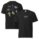 Two black heavyweight T-shirts displayed side by side, one showing the front and one the back. The front features ‘MORBID’ stacked three times centered on the chest, with two white lines above one purple line. The back shows a large collage of vintage-style illustrations including overlapping skulls shaded in purple, a stack of books, a raven, a crystal ball, a horned devil figure, a gothic window frame, a candle in purple, and wide eyes, with ‘MORBID’ stacked in purple at the center.