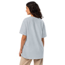 Shows the rear of an oversized light blue t-shirt with no visible graphics, modeled by a person standing with their body turned slightly to the side.