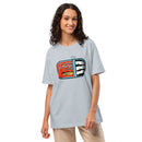 Woman smiling and wearing a light blue unisex t-shirt with a colorful 'Summer S’mores with Conan & the Chill Chums' sardine can design on the chest.