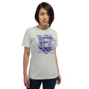 Athletic heather short-sleeve t-shirt with a large blue graphic reading 'COMEDY BING BONG WITH SCOTT AUKERMAN' and an illustrated face on the right. Worn by a woman standing with hands at her sides, dressed in jeans, against a plain background.