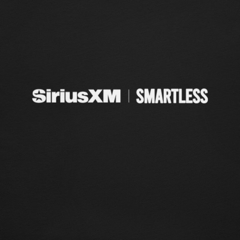 Close-up of the back of a black T-shirt showing two small white logos centered near the neckline: ‘SiriusXM’ on the left and ‘SMARTLESS’ on the right.
