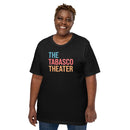 Smiling woman wearing a black T-shirt with a bold, colorful graphic that reads ‘THE TABASCO THEATER’ in large, lit-up marquee-style font in blue, red, and orange.