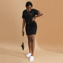 A woman standing and smiling while wearing a black heather T-shirt with the red text 'LEAVE IT IN, SHANTEL' on the left chest, paired with a black zip-front skirt and white slip-on shoes.