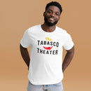 A man smiling while wearing a white T-shirt printed with 'The TABASCO THEATER' and a red chili pepper icon between the words.