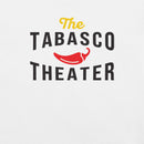 A close-up of a white shirt showing the design that reads 'The TABASCO THEATER' in stylized black and yellow lettering, with a red chili pepper illustration in the center.