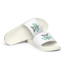 A pair of white slides placed diagonally on a white background, both featuring a green and gray 'STAYING ALIVE' graphic and a caduceus symbol, a winged staff wrapped with two snakes, printed across the foot straps.